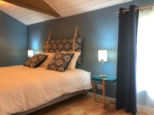 une chambre avec un lit et un mur bleu dans l'établissement Le bois aux feuilles blanches, à Saint-Michel-Mont-Mercure