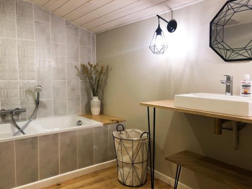 une salle de bain avec une baignoire et un lavabo dans l'établissement Le bois aux feuilles blanches, à Saint-Michel-Mont-Mercure