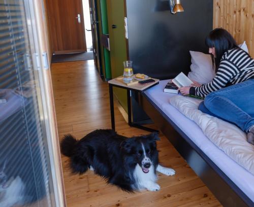 a woman sitting on a couch with a dog on the floor at Almenland Apartment Passail in Passail