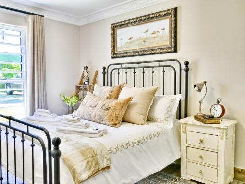 豪特灣的住宿－dk villas 4 Riverview, Hout Bay，一间卧室配有带白色床单和枕头的床。