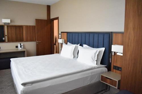 a bedroom with a large bed with white sheets and pillows at Hotel Bulgaria in Burgas City
