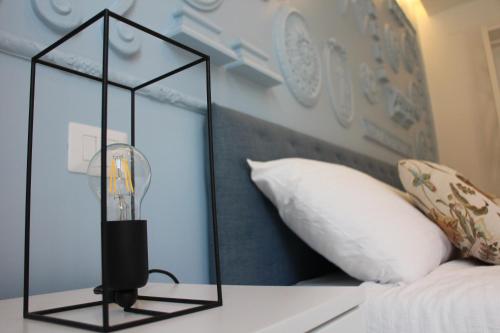 a lamp on top of a bed with a pillow at Il Cavaliere Bed and Breakfast in Caserta