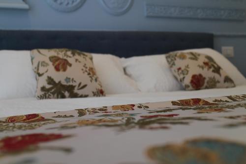 a bed with two pillows and a bed with avertisement at Il Cavaliere Bed and Breakfast in Caserta