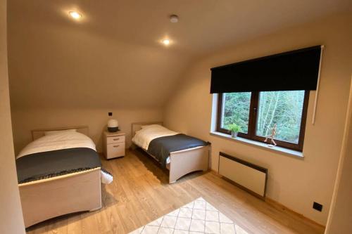 1 dormitorio con 2 camas y ventana en Gîte Chez Mamy Léa à deux pas du centre, en La-Roche-en-Ardenne