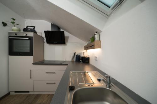 a kitchen with a sink and a stove top oven at Ferienwohnung Jubiläumsgrat in Grainau