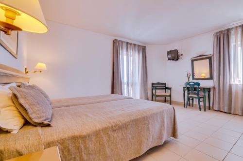 a hotel room with a bed and a table at Hotel Mar A Vista in Albufeira