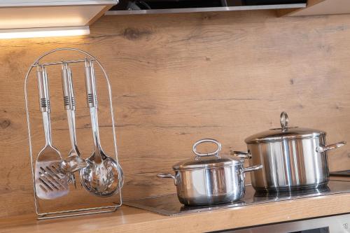 two pots and pans and spoons on a kitchen counter at Appartement Frühstückspension Landhaus Karwendel in Pertisau