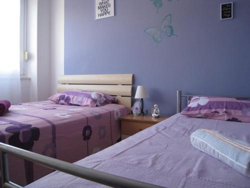 2 camas en un dormitorio con mariposas en la pared en Apartment Ella Mare en Zadar