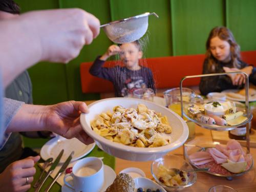 a group of people sitting at a table eating food at Almenland Apartment Passail in Passail