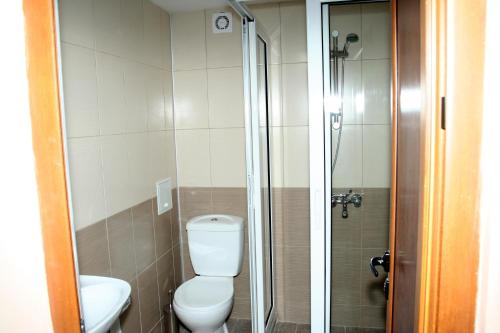 a bathroom with a toilet and a shower at Interrum Hotel in Razgrad