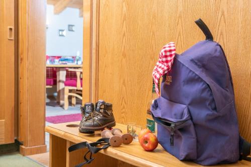 a purple backpack sitting on top of a table with apples at Appartement Frühstückspension Landhaus Karwendel in Pertisau