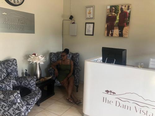 a woman sitting on a chair next to a counter at Dam Vista Retreat in Giyani