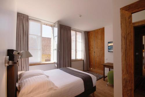 a hotel room with a bed and a window at Le Jardin Découverte in Conches-en-Ouche
