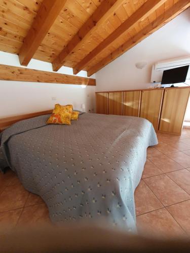 una camera con letto in una stanza con soffitti in legno di Residence Celeste a Mezzegra