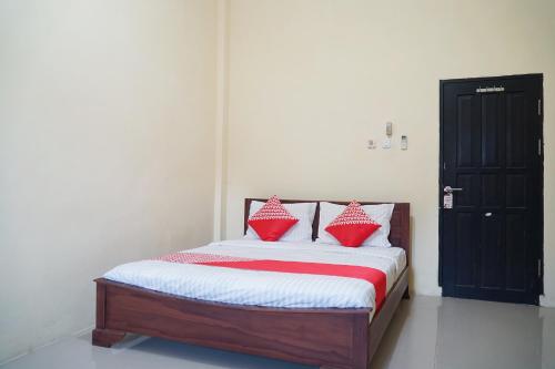 سرير أو أسرّة في غرفة في OYO Flagship 1034 Pondok Mulia Guest House Syariah
