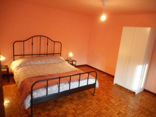 1 dormitorio con cama y pared de color naranja en Affittacamere Esteban, en Villa Opicina
