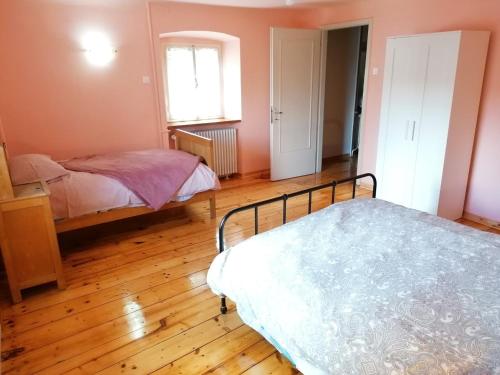 een slaapkamer met 2 bedden en een houten vloer bij Affittacamere Esteban in Villa Opicina