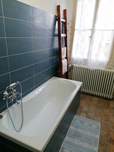 y baño con bañera y azulejos azules. en Affittacamere Esteban, en Villa Opicina
