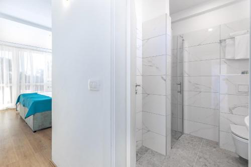 a white bathroom with a shower and a toilet at Annex Slaven in Selce