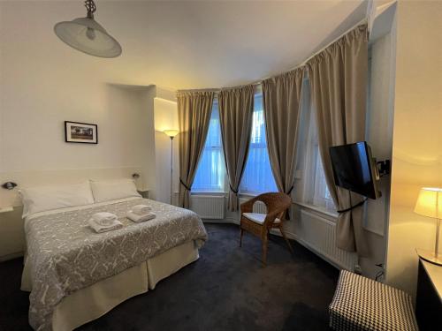 a hotel room with a bed and a television at The Gateway Hotel in London