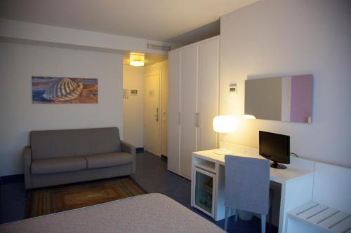 a room with a desk and a chair and a television at Aurea Hotel in Tortoreto Lido