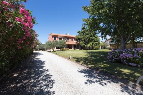a driveway leading to a house with flowers at Rooms Alla Beccaccia in Fažana