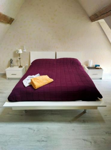 - une chambre avec un lit violet et 2 tables de chevet dans l'établissement La Maison entièrement équipée - Boulangerie, à Saint-Pierre-les-Étieux