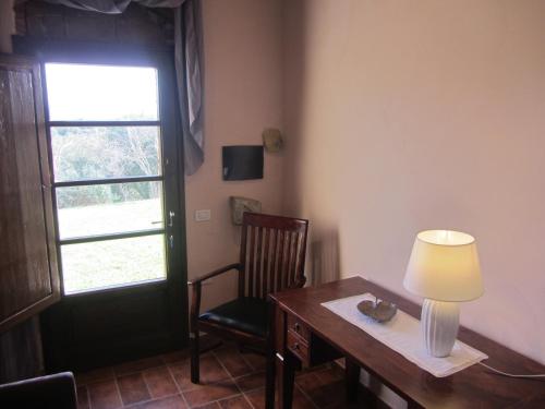 a room with a desk with a lamp and a chair at Tenuta Seripa in Sassetta