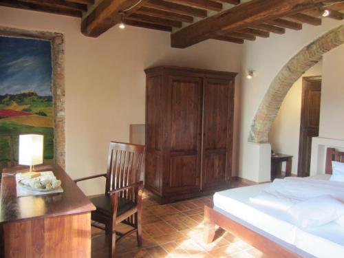 a bedroom with a bed and a table and a chair at Tenuta Seripa in Sassetta