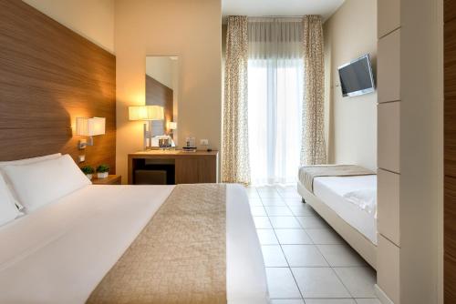a hotel room with a bed and a television at Hotel San Marco in Cattolica
