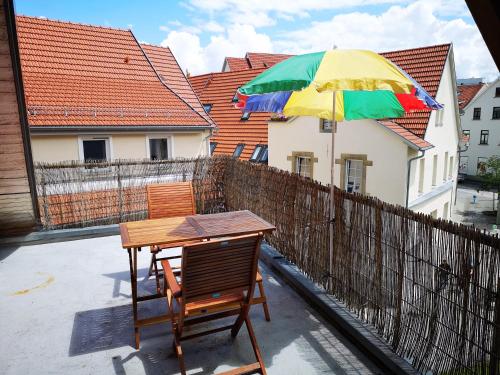 a table and chairs with an umbrella on a balcony at charmante Pension zentral in Reutlingen