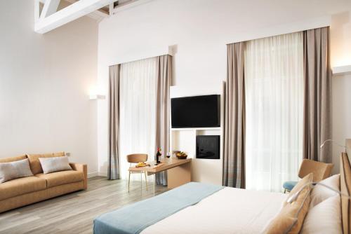 a hotel room with a bed and a couch at Hotel Italia in Cagliari
