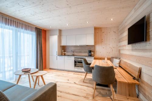 a kitchen and living room with a table and chairs at Naturhaus am Arlberg in Warth am Arlberg