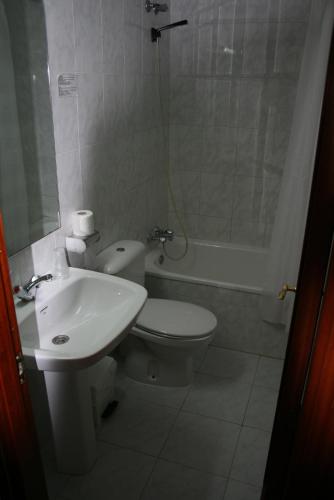 a bathroom with a toilet and a sink and a shower at Hostal Puente de Piedra in Zaragoza
