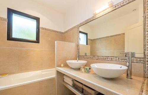韋基奧港的聖塔露西的住宿－VILLA TORRACCIA 4 Étoiles，一间带两个盥洗盆和大镜子的浴室