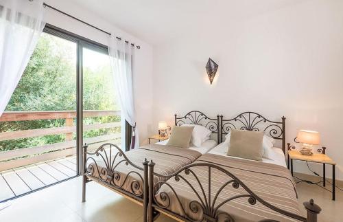 une chambre avec un lit et une grande fenêtre dans l'établissement VILLA TORRACCIA 4 Étoiles, à Sainte-Lucie de Porto-Vecchio