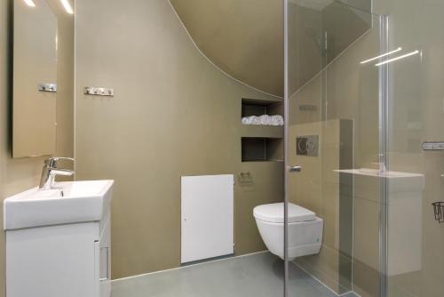 a bathroom with a toilet and a glass shower at Central Studio Apartment Apt 102 in Stavanger