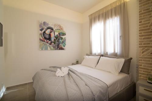 een slaapkamer met een bed en een schilderij aan de muur bij Lodge Apartments in Zakynthos