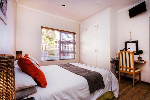 a bedroom with a bed and a window and a chair at 49 on Cliff in Gansbaai