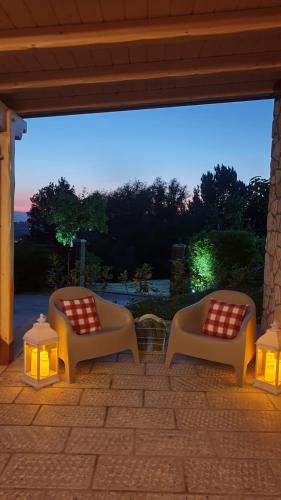 two chairs sitting on a patio with lights at Cà RosannA in Rocca San Felice