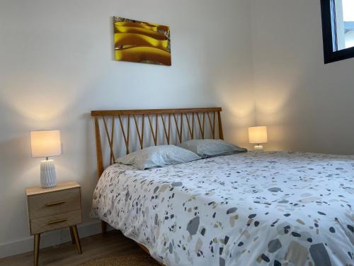 ein Schlafzimmer mit einem Bett mit zwei Lampen in der Unterkunft Villa L'espourguit proche de l'océan et de la forêt in Mimizan