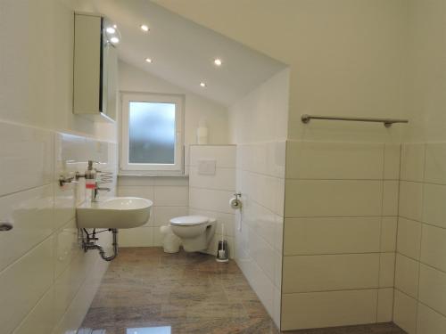 Un baño blanco con lavabo e inodoro. en Monteurhaus Scheidter 40, en Saarbrücken
