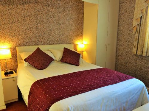 a bedroom with a large white bed with two pillows at White Lodge Guest House in Skegness