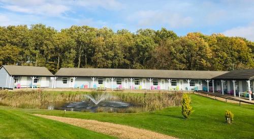 un edificio bianco con un laghetto di fronte di Silverstone Golf Club And Hotel a Silverstone