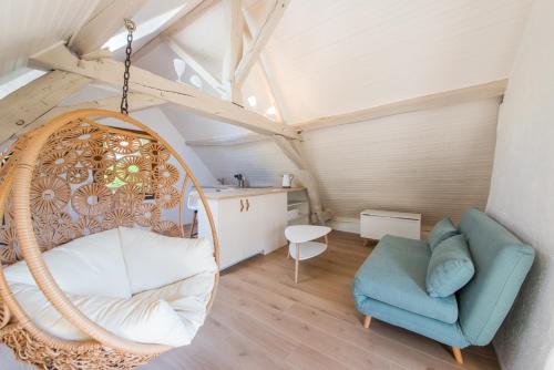 une chambre avec une balançoire et une chaise dans l'établissement Les Hauts de Manse, à Saint-Épain