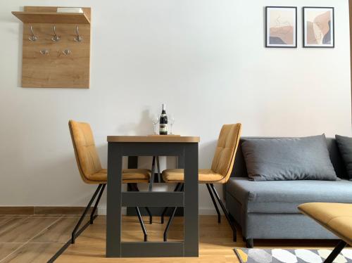 a table and chairs in a living room with a couch at Jahorina 7Lux in Jahorina