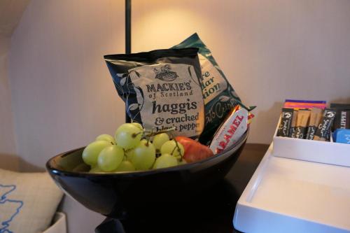 a bowl of fruit on a table with a bag of groceries at The Gordon Guest House in Ballater