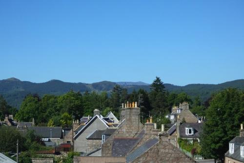 a view of houses in a town with mountains in the background at The Gordon Guest House in Ballater