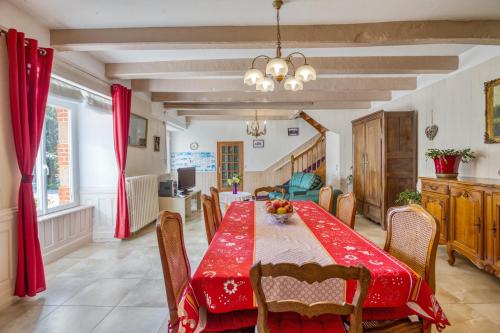 une salle à manger avec une table et des chaises rouges dans l'établissement Maison chaleureuse à Pordic avec jardin et cheminée, à Pordic