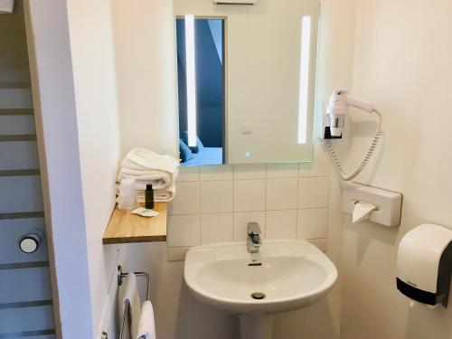 a small bathroom with a sink and a mirror at Logis Hôtels- Hôtel Marguerite d'Anjou Angers château in Angers